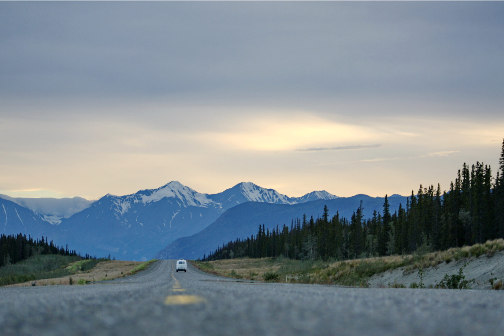 Une voiture roule en direction des montagnes