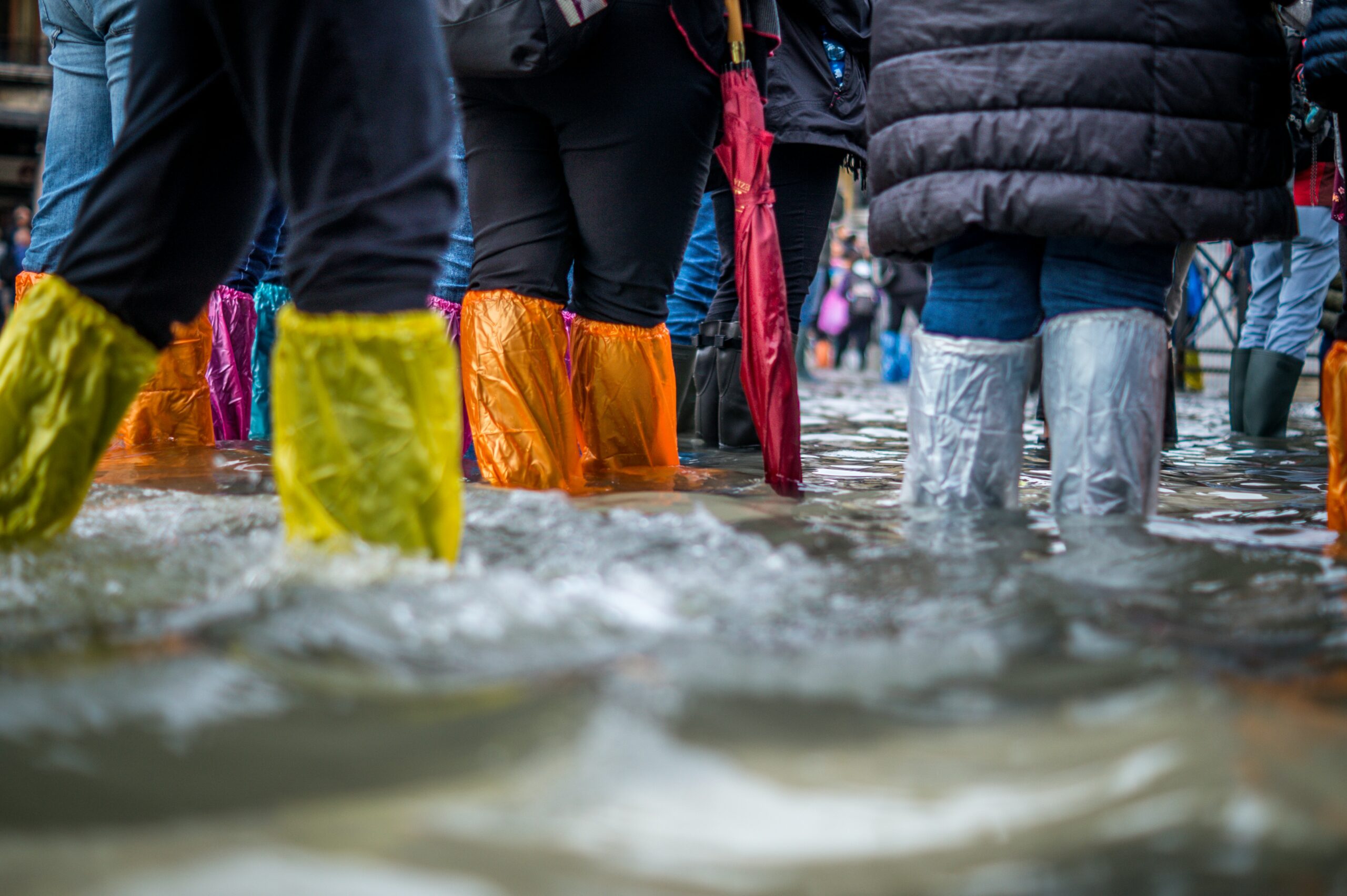 Personas con botines de plástico en Venecia