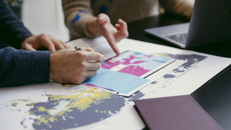 Two people collaborating over print outs of Probable Future maps